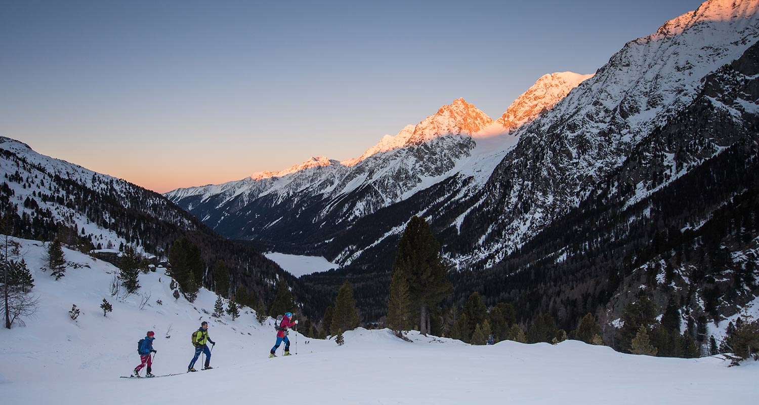 Group of cross-country skiers at sunset in a snow-covered landscape