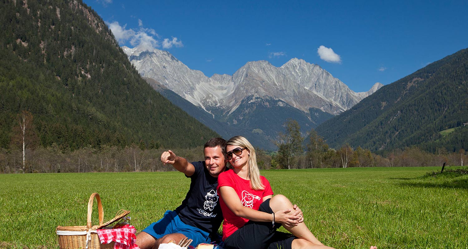 Couple having a picknick on a moutain meadow on a beautiful summer day